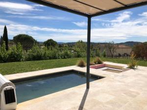 une piscine dans un patio avec un parasol dans l'établissement La Petite Reine, à Villes-sur-Auzon