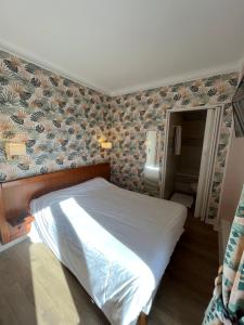 a bed in a bedroom with a wall at Aux Quatre Vents in Saulieu