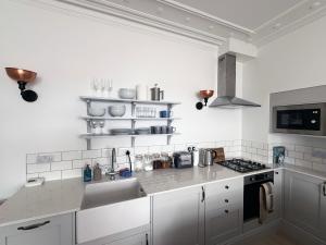 Una cocina blanca con fregadero y estufa. en Bay View Cottage, en Fairlie