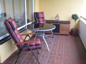 Ein Tisch und zwei Stühle stehen auf einem Balkon in der Unterkunft BnB Faas in Wittlich