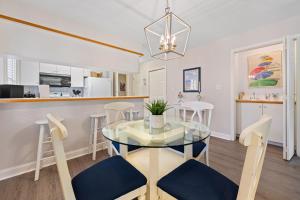a dining room and kitchen with a glass table and chairs at Fairways & Ocean Breeze condo in Pawleys Island