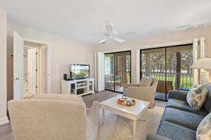 a living room with a couch and chairs and a tv at Fairways & Ocean Breeze condo in Pawleys Island +12 photos