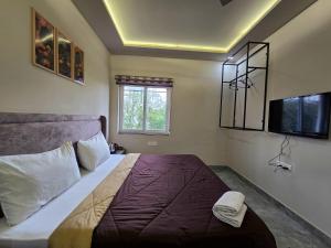 a bedroom with a large bed and a tv at Zipcode Stay in Agra