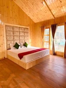 a bedroom with a large bed in a room with wooden walls at Dahar Retreat - A Boutique Homestay in Kotla
