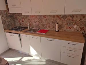 a kitchen with white cabinets and a sink at Casa del Celo in Rapallo