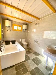 a bathroom with a tub and a toilet and a sink at Dahar Retreat - A Boutique Homestay in Kotla