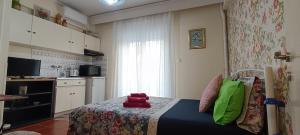 a small bedroom with a bed and a kitchen at Floral Tribute Studio in Kavála