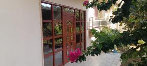 an open door to a building with pink flowers at Floral Tribute Studio in Kavála