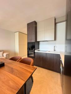 a kitchen with a wooden table with chairs and a kitchen counter at SeaBreeze Resort Baku Apartment Studio in Baku