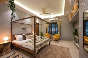 a bedroom with a canopy bed and yellow chairs at EKOSTAY - Noir Villa in Alibaug +14 photos