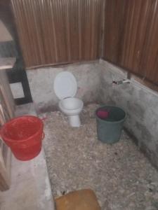 a bathroom with a toilet and two buckets at Mamere Homestay Raja Ampat in Fam