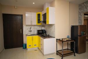 een keuken met gele en witte kasten en een koelkast bij Just Move Premium 2BR Suite, Near ISB Int'l AIRPT in Islamabad