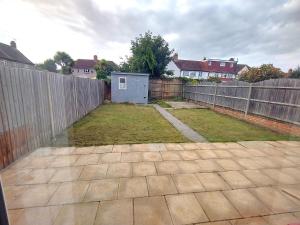an empty backyard with a fence and a yard at Enyo House Brentford London in Brentford