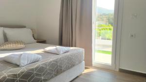 VotsalákiaにあるKamara Luxury ground floor apartmentsの枕が2つ付いたベッドと窓のある寝室