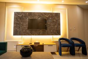 een kamer met een tv, een stoel en een bureau bij Just Move Premium 2BR Suite, Near ISB Int'l AIRPT in Islamabad