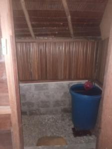 a blue bucket in a room with a wooden wall at Mamere Homestay Raja Ampat in Fam