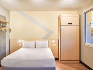 a bedroom with a large white bed and a door at ibis budget Issy Les Moulineaux Paris Ouest in Issy-les-Moulineaux