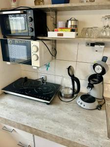 a kitchen counter with a stove and a microwave at EasyStay#1 Cozy Studio in Kliniknähe, mit Netflix,Küche & Bad in Bad Oeynhausen +4 photos