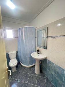 un baño con inodoro y lavabo en Andria Apartment, en Sarandë 8 fotos más
