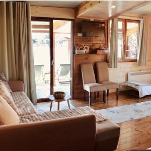 een woonkamer met een bank en stoelen en een raam bij Vuk - Ada Bojana in Ulcinj