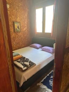 een kleine slaapkamer met een bed en een raam bij Vuk - Ada Bojana in Ulcinj