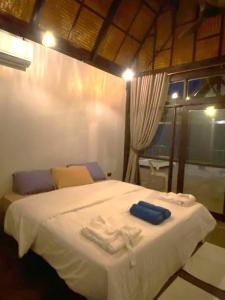 ein Schlafzimmer mit einem weißen Bett mit Handtüchern darauf in der Unterkunft Dalasone Pool Villa with Stunning Mountain View in Vang Vieng + 14 Fotos