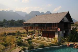 ein Haus mit einem Balkon und einem Pool in der Unterkunft Dalasone Pool Villa with Stunning Mountain View in Vang Vieng