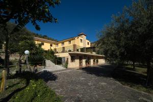 a large building with a staircase leading up to it at Agriturismo Villa Orchidea in Alì Terme