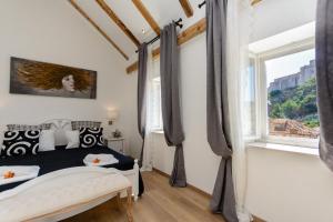 a bedroom with a black and white bed and a window at Dubrovnik Finest Apartments in Dubrovnik