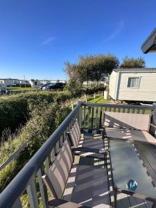 une terrasse avec deux chaises et une table. dans l'établissement Caravan Selsey, à Selsey