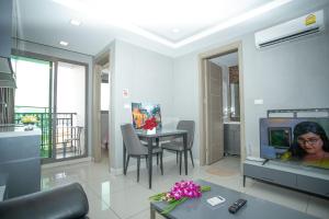 a living room with a tv and a table with chairs at Arcadia阿卡迪亚二期 in Pattaya South