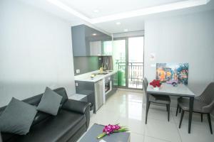 a living room and kitchen with a couch and a table at Arcadia阿卡迪亚二期 in Pattaya South