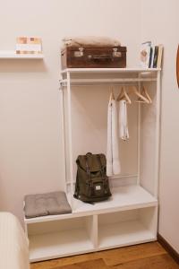 a white closet with a black bag on a shelf at La Casa Sull'Albero Bilocale a due Passi da San Lorenzo in Genova