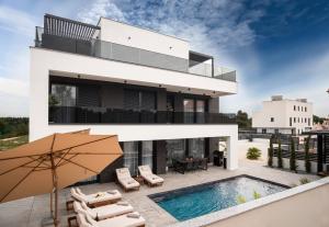 una casa con piscina e ombrellone di Luxury Villa Vesper- Private Heated Pool, Hot Tub, Rooftop terrace a Vodice