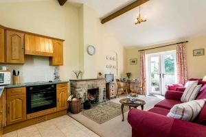 a kitchen with a living room with a fireplace at Character Farm Cottages, 5 cottages near Dorset Coast in Portesham