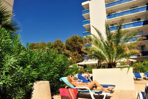 two women laying in lounge chairs at a resort at Résidence GOELIA Sun City in Montpellier