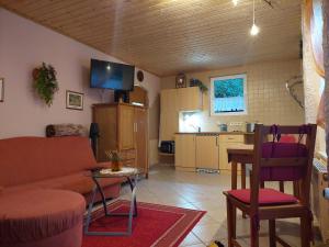 a living room with a couch and a table and a kitchen at Waldresidenz in Neubrandenburg