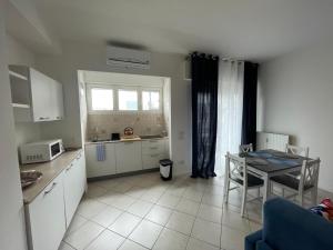 eine Küche mit weißen Schränken und einem Tisch und einem Fenster in der Unterkunft QUEEN HOME VENICE TRAIN STATION Noemi & Angel in Venedig