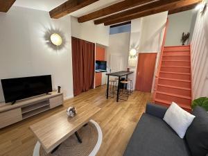 a living room with a couch and a tv and a table at Escapade Provençale à Manosque - Centre Historique in Manosque