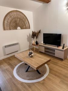 a living room with a television and a coffee table at Escapade Provençale à Manosque - Centre Historique in Manosque