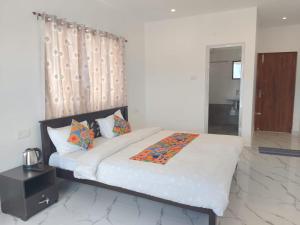 Un dormitorio con una cama grande con sábanas y almohadas blancas. en THE DEW stay, en Kodaikanal 17 fotos más
