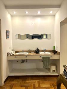a bathroom with two sinks and a large mirror at La mejor opción para tu estadía en Córdoba con amigos in Cordoba