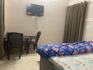 una stanza con un letto, un tavolo e una tv di Prakash homestay a Ayodhya