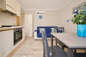 a kitchen and living room with a table and a blue couch at Il Giglio in San Vincenzo +12 photos
