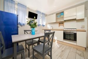 a kitchen with a table with chairs and a vase of flowers at Il Giglio in San Vincenzo