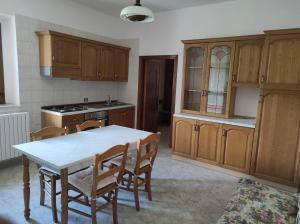a kitchen with wooden cabinets and a table and chairs at B&B Da GIOVANNI in Masseria di Rusciano