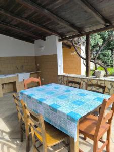 a table and chairs on a patio with a blue tile roof at ViLLA GASPARE FRONTE MARE in Favignana +30 photos