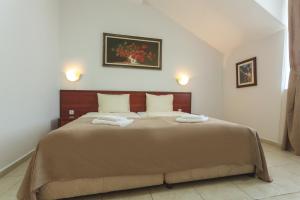 a bedroom with a large bed with two towels on it at Hotel CENTRAL Balchik in Balchik