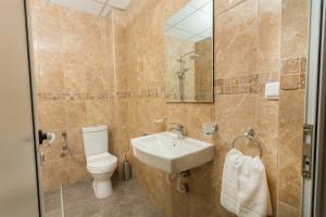 a bathroom with a toilet and a sink at Hotel CENTRAL Balchik in Balchik