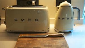 two toasters sitting on a counter next to a knife at The Poets' Retreat in Sulmona